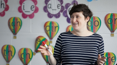 Female teacher stood in classroom in front of a display board