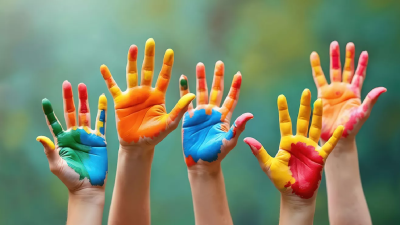 Children holding up their hands which are covered in paint