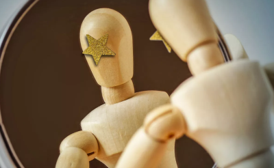 Wooden figure looking in a mirror