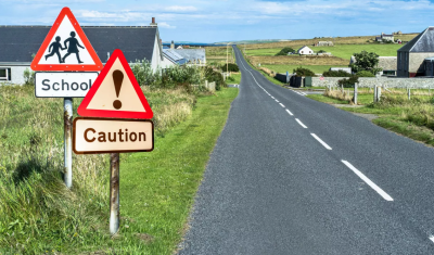 Countryside road with caution and school signs