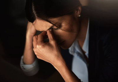 Woman holding head in hands