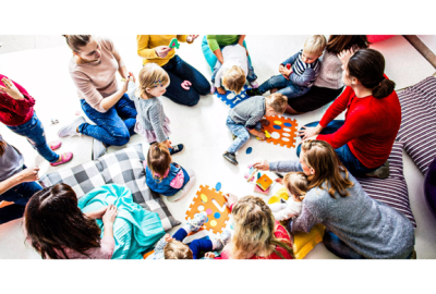 Families sat on floor playing with their children